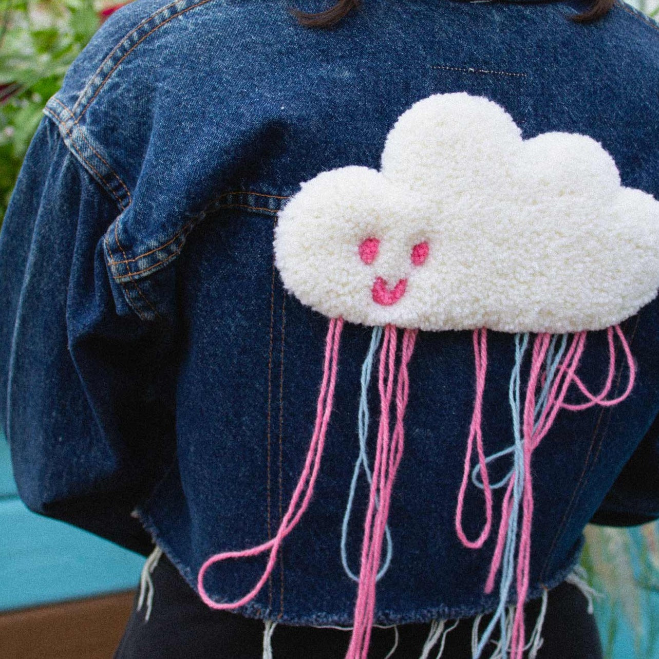 Upcycled jean jacket with cloud rug behind