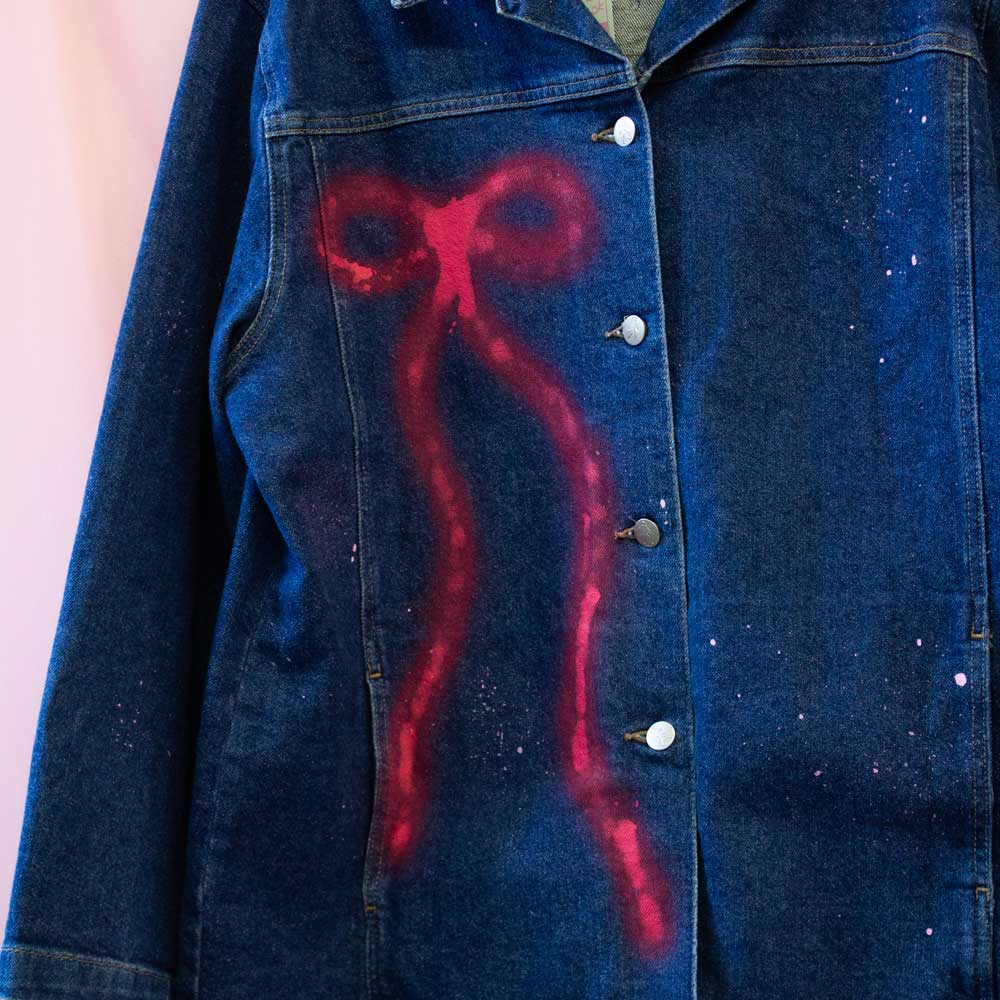 Veste en jeans upcyclée peinturée en aérosol — chat aux boucles rouges