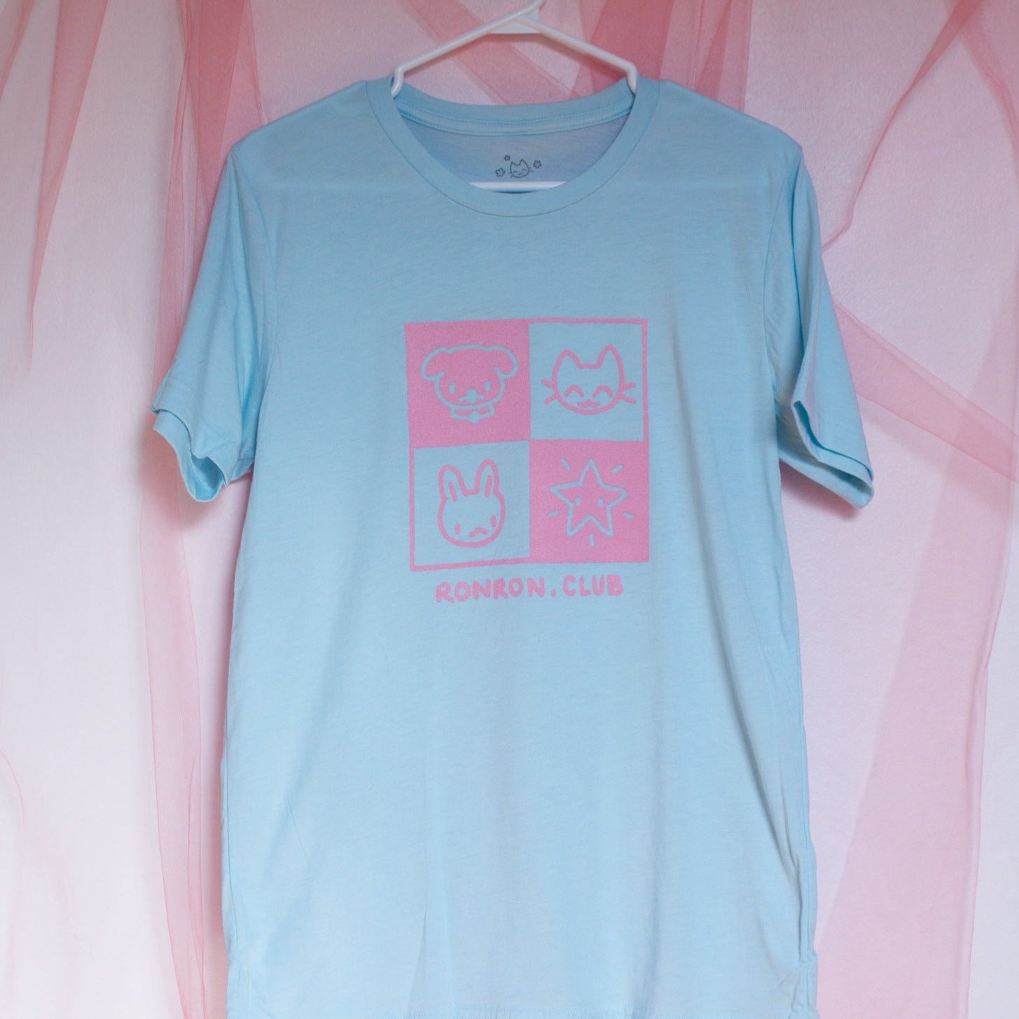 Photo du t-shirt bleu pâle avec imprimé rose "Ronron.club" avec petits animaux et une étoiles